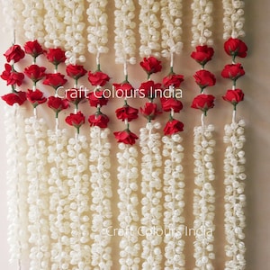May include: A garland of white jasmine flowers with red rose accents. The garland is made of artificial flowers and is perfect for decorating for a wedding or other special occasion. Craft Colours India.