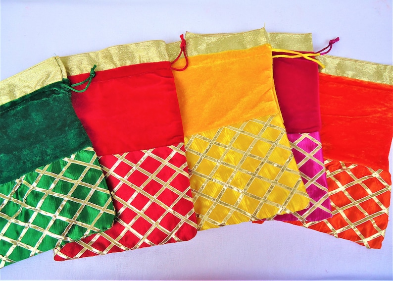 May include: Five colorful drawstring bags with gold trim and a diamond pattern. The bags are made of velvet and have a variety of colors, including green, red, yellow, pink, and orange.