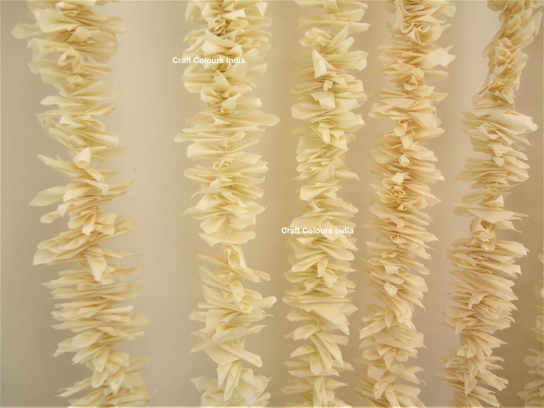 May include: A close-up of a cream-colored paper garland, with the text "Craft Colours India" printed on two of the garlands.