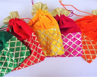 May include: Four velvet drawstring bags with gold trim and a diamond pattern. The bags are in green, red, yellow, and orange.