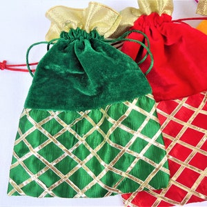May include: Three drawstring bags with gold trim and a diamond pattern. The bags are green, red, and orange.