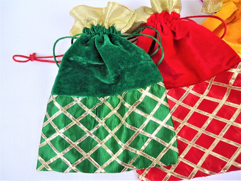 May include: Three drawstring bags with gold trim and a diamond pattern. The bags are green, red, and orange.