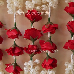 May include: Red and white artificial flower garland with the text "Craft Colours India" printed twice.