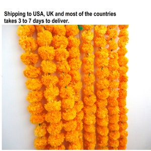 May include: A garland of bright yellow marigold flower blossoms strung together. The garland is made of paper and is a traditional decoration for Indian festivals and celebrations.