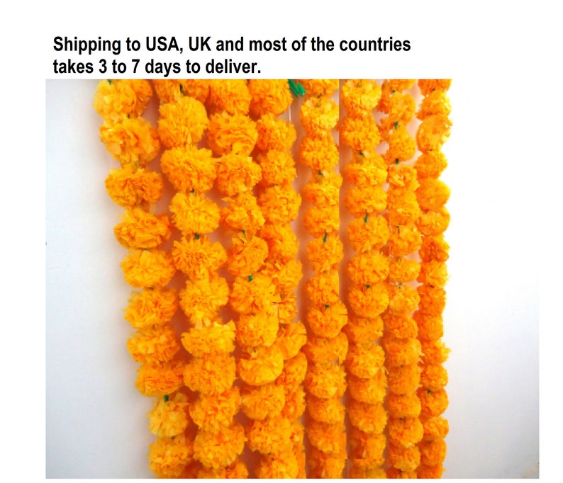 May include: A garland of bright yellow marigold flower blossoms strung together. The garland is made of paper and is a traditional decoration for Indian festivals and celebrations.