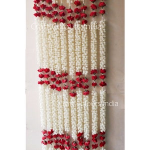 May include: A white and red floral garland with a repeating pattern of white jasmine flowers and red roses. The garland is made of artificial flowers and is perfect for decorating a doorway or wall.
