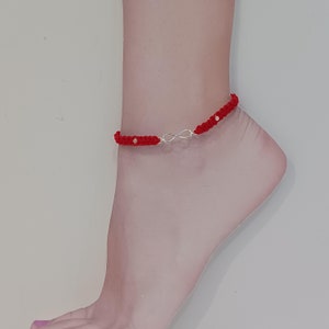 May include: Red string anklet with a silver infinity charm and small silver beads.