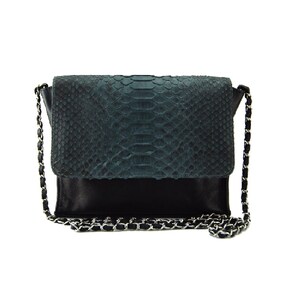 Può includere: Una borsa a tracolla in pelle di serpente nera e turchese con una catena argentata.