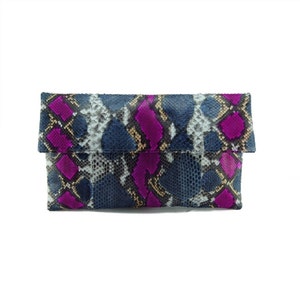 May include: A blue and purple snakeskin clutch bag with a flap closure.
