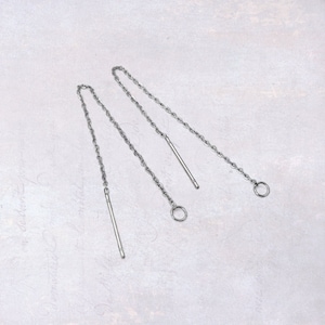 May include: A pair of silver chain earrings with a small circle at the end of each chain. The chains are attached to a small, straight, silver bar.
