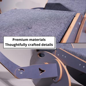 K&ouml;nnte beinhalten: Nahaufnahme eines grauen Schaukelstuhls mit Holzakzenten. Der Stuhl verf&uuml;gt &uuml;ber graue Stoffkissen und ein einzigartiges Design. Der Text auf dem Bild lautet "Premium materials" und "Thoughtfully crafted details".