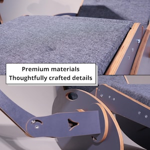 K&ouml;nnte beinhalten: Nahaufnahme eines grauen Schaukelstuhls mit Holzakzenten. Der Stuhl hat graue Stoffkissen und einen Holzrahmen. Der Text "Premium materials Thoughtfully crafted details" wird auf dem Bild angezeigt.