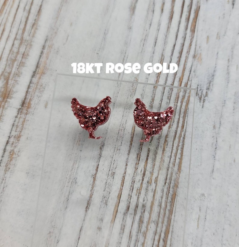 May include: A pair of rose gold chicken stud earrings. The earrings are made of glitter and have a shiny finish. 18KT ROSE GOLD.