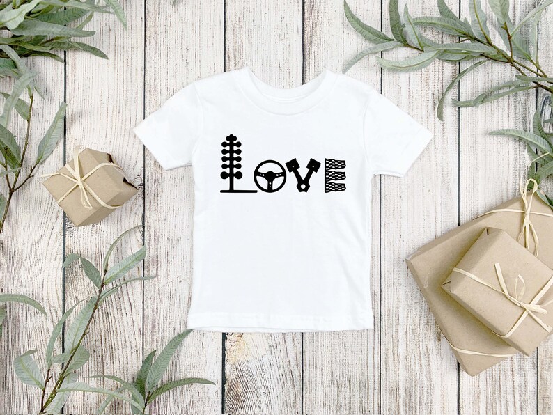 May include: White baby onesie with black racing-themed graphics spelling out the word "LOVE".