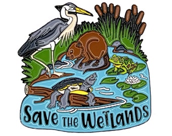 May include: Enamel pin depicting a wetland scene with a heron, beaver, turtle, and frog. The pin has a blue water background with the text "Save the Wetlands" in white. A colourful accessory.