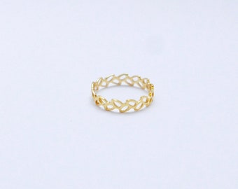 May include: A gold ring with a delicate, intricate design of interconnected ovals.