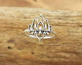 Puede incluir: Un anillo de plata con un delicado diseño de flor de loto. El anillo está hecho de plata de ley y es una pieza de joyería hermosa y única.