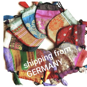 Può includere: Una collezione di sacchetti colorati con coulisse in vari modelli e colori, tra cui blu, rosa, arancione e rosso. I sacchetti hanno coulisse nere e sono realizzati in tessuto fantasia. Il testo "shipping from GERMANY" è visibile.