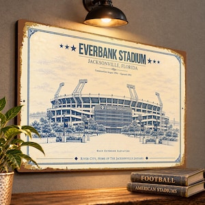 May include: A rectangular metal sign featuring a blue-toned architectural illustration of Everbank Stadium in Jacksonville, Florida. The text reads Everbank Stadium, Jacksonville, Florida, Construction began 1994 - Opened 1995, and River City, Home of The Jacksonville Jaguars.