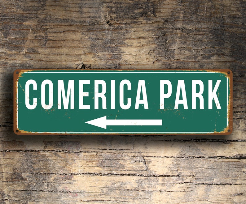 May include: A green and white metal sign with the text "Comerica Park" and a white arrow pointing to the left.