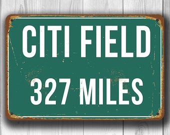Op de afbeelding: Een vintage metalen bord met een groene achtergrond en witte tekst. Het bord toont "Citi Field 327 Miles".
