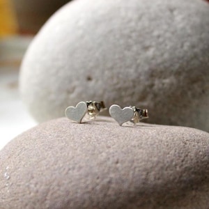 Peut inclure: Une paire de boucles d'oreilles en argent en forme de cœur. Les boucles d'oreilles sont petites et délicates, et elles sont parfaites pour un usage quotidien.