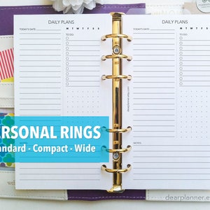 May include: A planner with gold rings and white paper inserts. The planner pages have sections for daily plans, with space for the date, to-do lists, and notes. The text "PERSONAL RINGS" and "Standard - Compact - Wide" is visible.