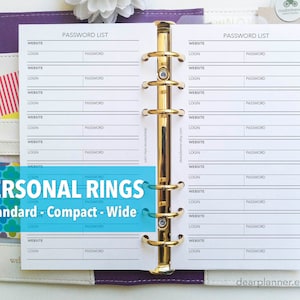 May include: A white planner with gold rings and a password list printed on the pages. The planner is open to a page with the words "PASSWORD LIST" at the top. The planner is labeled "PERSONAL RINGS Standard - Compact - Wide".