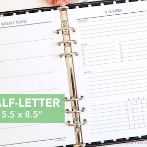 May include: A white planner with a black cover and polka dots. The planner is open to a weekly spread with a section for "Weekly Plans" and a section for "This Week". The planner is 5.5 inches by 8.5 inches.
