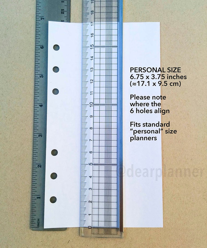 May include: A white sheet of paper with six holes punched along the left edge. The paper is measured with a ruler, showing it is 6.75 inches by 3.75 inches. The text on the paper reads "PERSONAL SIZE 6.75 x 3.75 inches (&asymp;17.1 x 9.5 cm) Please note where the 6 holes align Fits standard "personal" size planners".