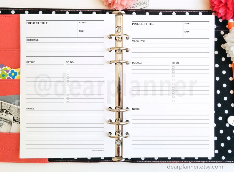 K&ouml;nnte beinhalten: Ein wei&szlig;er Planer mit schwarzen Linien und einem schwarz-wei&szlig;en Polka-Dot-Umschlag. Der Planer hat einen Metallringbinder und zwei Seiten, die zu einer Projektplanungsvorlage ge&ouml;ffnet sind. Die Vorlage hat Abschnitte f&uuml;r Projekttitel, Ziel, Details, zu erledigende Aufgaben und Notizen.