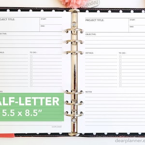 May include: A white planner with black lines and a green label that says "HALF-LETTER 5.5 x 8.5"  The planner is open to two pages with the words "PROJECT TITLE", "START", "END", "OBJECTIVE", "DETAILS", "TO DO", and "NOTES" printed on each page. The planner is bound with silver rings.