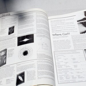 K&ouml;nnte beinhalten: Offenes Buch mit Seiten, die Text und Illustrationen &uuml;ber das Universum zeigen. Der Text "UNIVERSE" ist oben auf der linken Seite zu sehen. Der Text "Where, Carl?" ist auf der rechten Seite zu sehen.