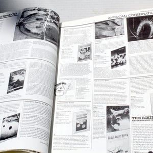 K&ouml;nnte beinhalten: Offene Buchseiten mit Text und Schwarz-Wei&szlig;-Bildern. Die linke Seite tr&auml;gt den Titel "WORLD CONSERVATION" und die rechte Seite den Titel "AMERICAN CONSERVATION". Zu den Bildern geh&ouml;ren Luftaufnahmen, Illustrationen und Zeitschriften-Cover.