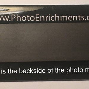 May include: A rectangular black photo magnet with the text "www.PhotoEnrichments.com" at the top and "This is the backside of the photo magnet" at the bottom. The magnet is wrapped in clear plastic.