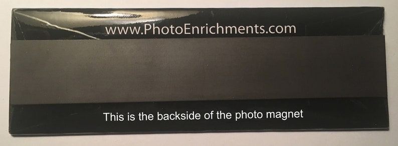 May include: A rectangular black photo magnet with the text "www.PhotoEnrichments.com" at the top and "This is the backside of the photo magnet" at the bottom. The magnet is wrapped in clear plastic.