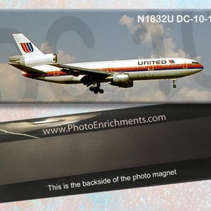 May include: A magnet depicting a United Airlines DC-10-10 aircraft in flight against a cloudy sky. The magnet has the text "N1832U DC-10-10" and "UNITED". The bottom portion of the magnet is black with the text "www.PhotoEnrichments.com" and "This is the backside of the photo magnet."