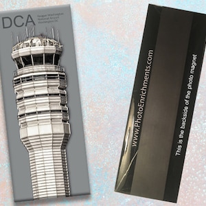 Könnte beinhalten: Ein Schwarzweiß-Fotomagnet mit dem Kontrollturm des Reagan Washington National Airport in Washington, D.C. Der Magnet hat den Text "DCA" und "www.PhotoEnrichments.com" auf der Rückseite.