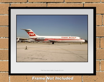 Puede incluir: Un avión Douglas DC-9-34 vintage de TWA Trans World Airlines con librea roja y blanca. El avión está estacionado en una pista con un cielo azul de fondo.