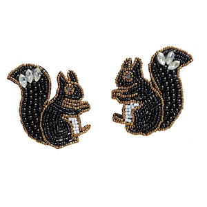 May include: A pair of beaded squirrel earrings. The earrings are made with black beads, gold accents, and white details. Clear, sparkling embellishments are placed on the tail. The earrings are designed to be worn on the ear.