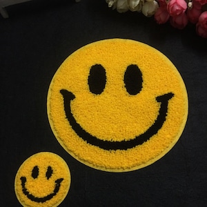 May include: Two yellow smiley face patches with black outlines. The larger patch is about 10 cm in diameter and the smaller patch is about 5 cm in diameter.