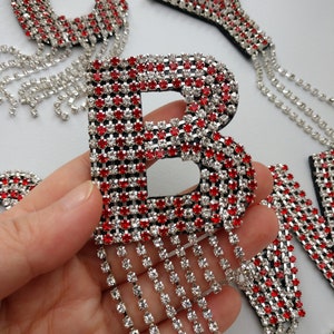 May include: Red and clear rhinestone letter B with a fringe of clear rhinestones.