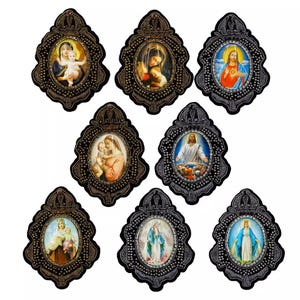 May include: A collection of eight religious icon pendants. Each pendant features a framed image of religious figures, including Mary and Jesus. The frames are dark with ornate detailing and a beaded border. The images are colorful and detailed.