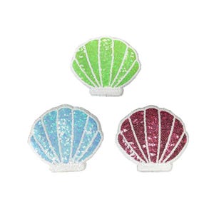 May include: Three sequined seashell patches in green, blue, and red. Each patch has a white, scalloped border and is filled with shimmering sequins. The patches are arranged on a white background.