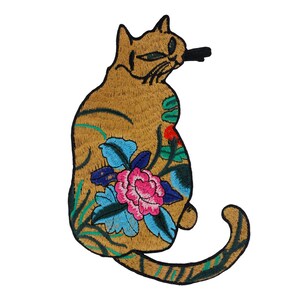 May include: Embroidered iron-on patch featuring a brown cat with a floral design. The cat is sitting with its tail curled around its body. The flowers are pink, blue, green, and red.