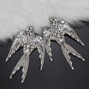 Puede incluir: Dos apliques de golondrina de plata con brillantes y lentejuelas transparentes. Los apliques son perfectos para añadir un toque de brillo a la ropa, los bolsos o la decoración del hogar.