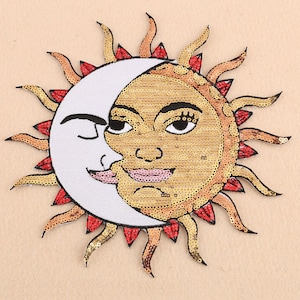 Può includere: Una toppa ricamata in oro e bianco con un design di sole e luna. Il sole ha un viso sorridente e la luna ha un occhio chiuso. Il sole e la luna sono circondati da raggi rossi e arancioni.