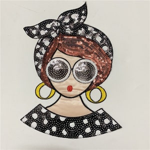 Può includere: Un cerotto di paillettes nero e bianco con un'immagine di cartone animato di una donna che indossa grandi occhiali da sole, una fascia per capelli e orecchini. La donna ha i capelli rossi e un viso rosa.