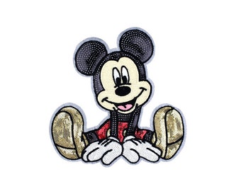 May include: A black and yellow sequined iron-on patch featuring Mickey Mouse sitting with a big smile.