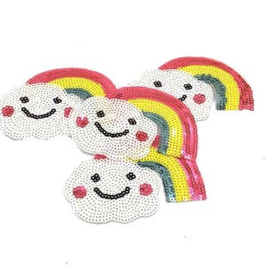 May include: Five colorful rainbow and cloud iron-on patches with smiling faces. The patches are made of sequins and are perfect for adding a whimsical touch to clothing, bags, or other accessories.